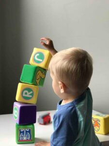little boy stacking blocks in a nursery